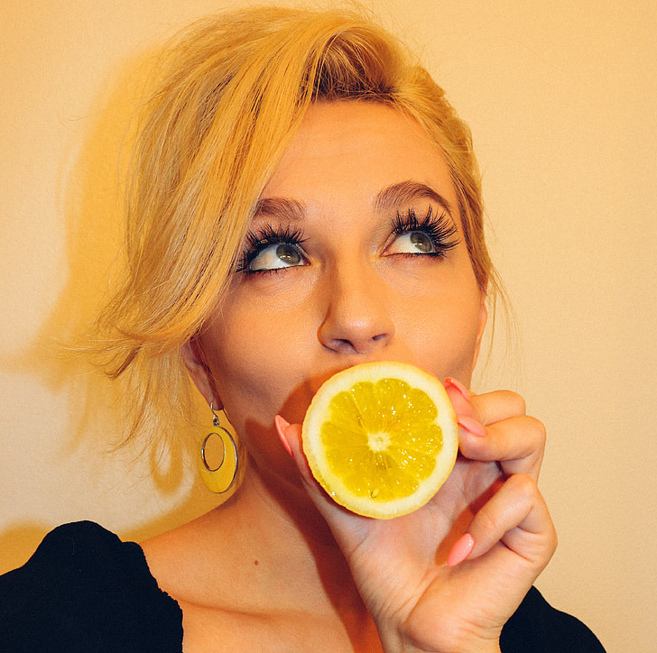 woman holding lemon while eyes rolling