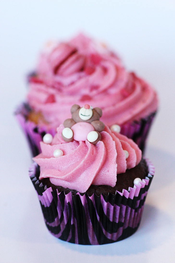 selective focus photography of pink and black cupcake