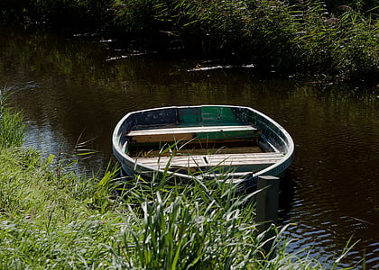 photo of green canoe on top of body of water during daytime