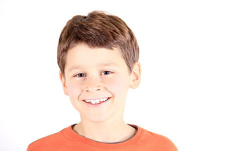 boy smiling wearing orange crew-neck top