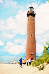 people walking at base of beige lighthouse