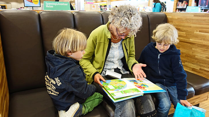 woman with two kids reading book