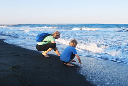 girl and child sitting on seashore