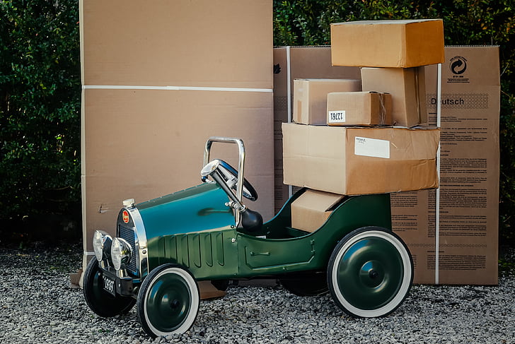 classic green car loaded with brown cardboard boxes