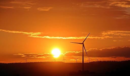 windmills under orange sky during golden hour