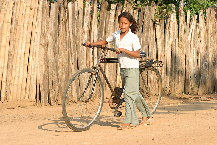 girl carrying black bicycle