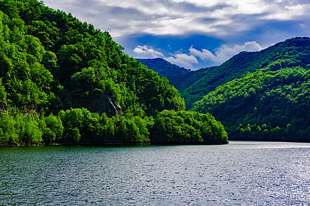 green mountain near body of water during daytime