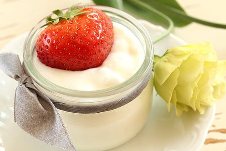 strawberry on top of cream in jar
