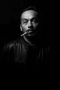 man in black leather jacket with cigarette stick