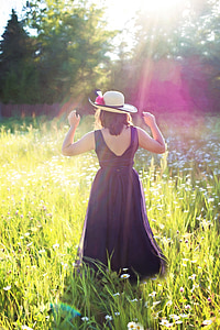 woman in black sleeveless dress walking at the fields