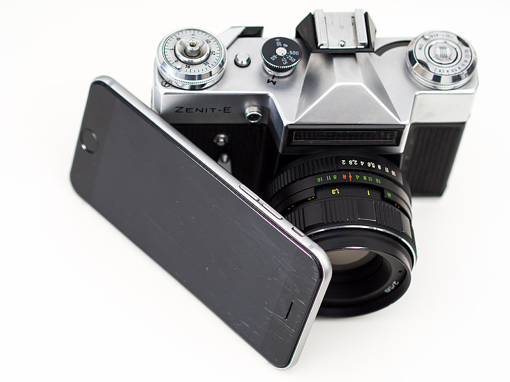 gray Zenit-E camera beside black smartphone