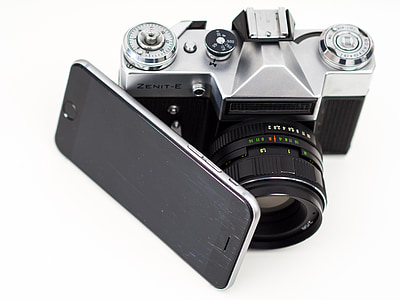 gray Zenit-E camera beside black smartphone