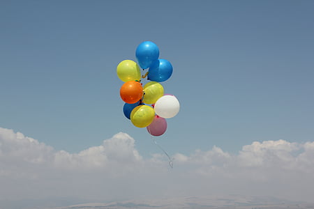 assorted color of balloons floating in clouds