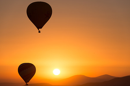 two hot-air balloons silhouette during golden hour