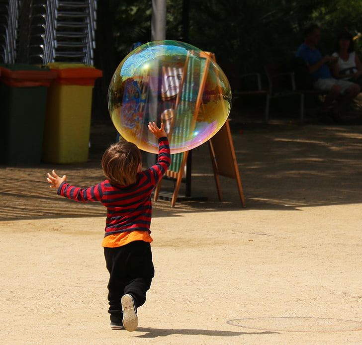 boy playing with bubble during daytime