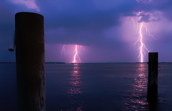 photo of lightning struck near body of water during nighttime