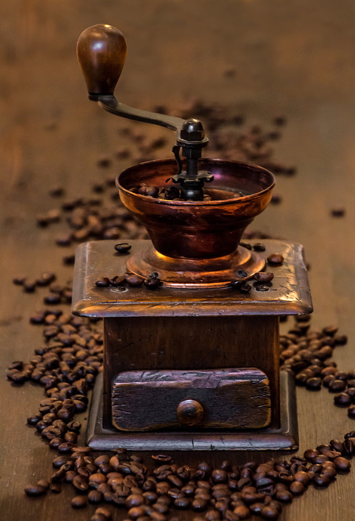 shallow focus photography of brass-colored coffee grinder