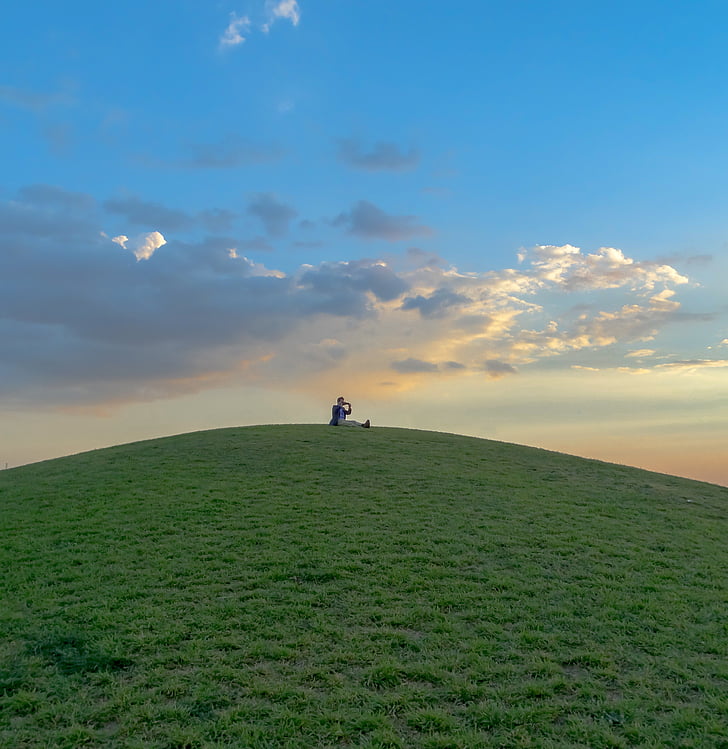 person sitting on top of hills