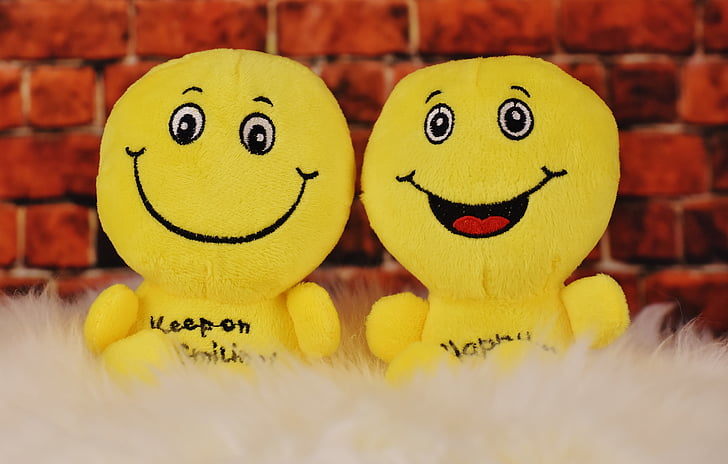 two yellow emoji plush toys