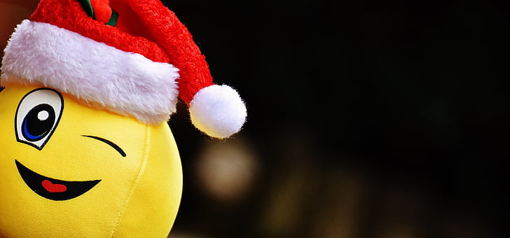 selective focus photo of yellow emoticon with Santa hat