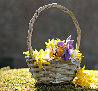yellow and purple flowers in brown wicker basket