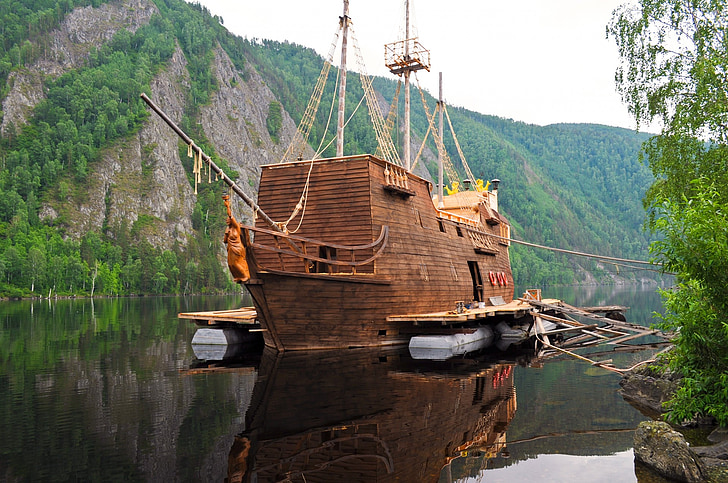 brown wooden ship on body of water at daytime