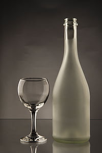clear glass bottle besides wine glass