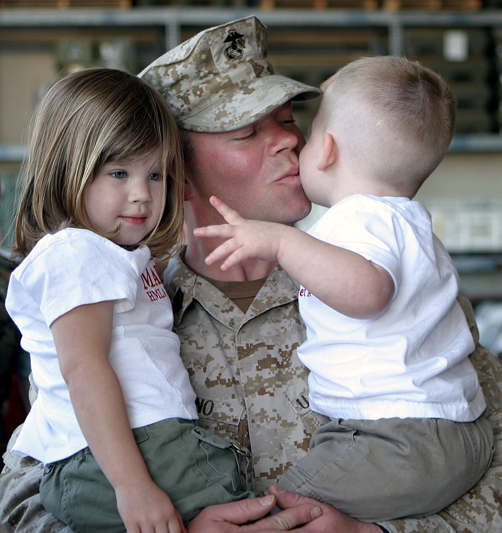 soldier carrying a two babies