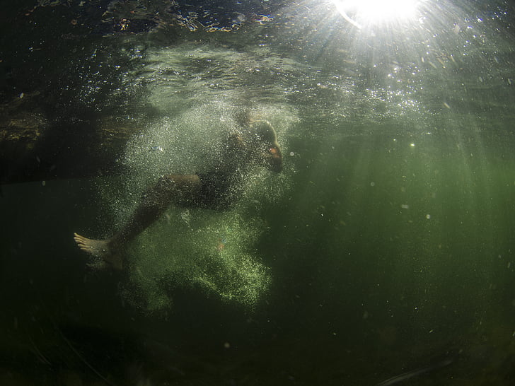 man diving in body of water