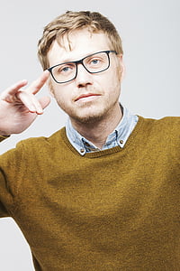 man wearing brown sweater and eyeglasses