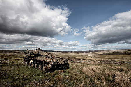 photo of brown military tank parked on grass during daytime