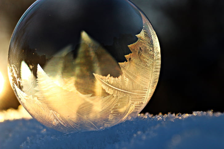 round clear glass ball on top of snow