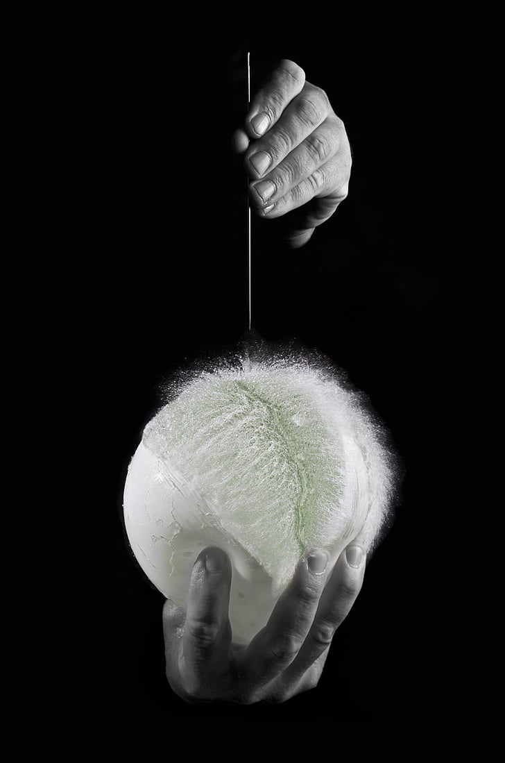 grayscale photo of person holding needle and balloon
