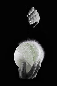 grayscale photo of person holding needle and balloon