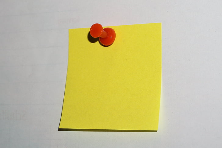 yellow sticky note and red push pin