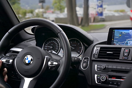 person holding black BMW steering wheel