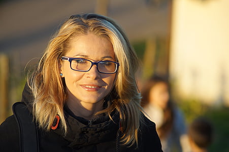 selective focus photography of woman wearing black framed eyeglasses and black coat