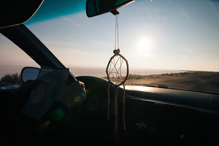 round white rope dream catcher hanged on vehicle rear-view mirror inside vehicle