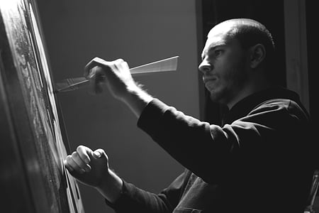 grey scale photo of man painting