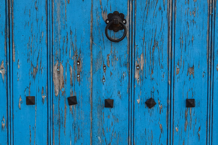 blue wooden door with black steel knocker