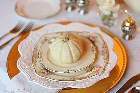 small artificial squash on white ceramic saucer with plates