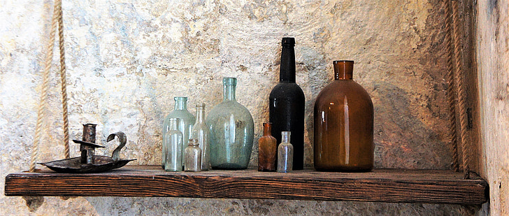 glass bottles on brown wooden floating shelf