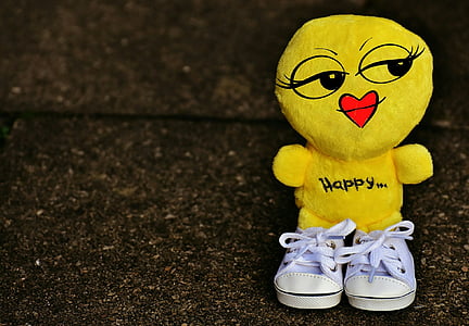 yellow plush toy with teal sneakers close-up photo