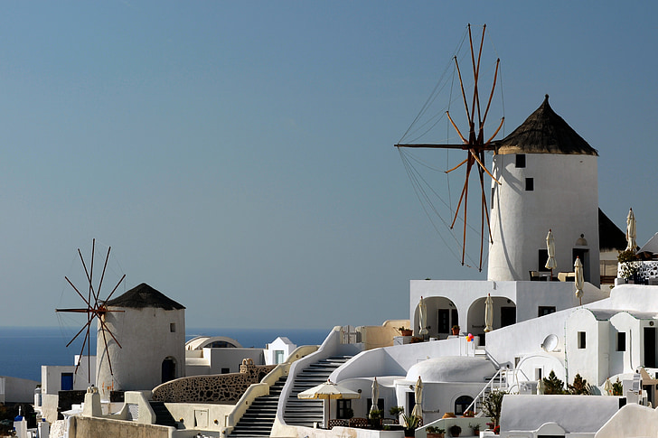 white painted buildings with windmill under blue sky at daytime
