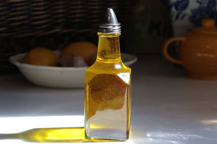 clear glass bottled olive on white wooden table