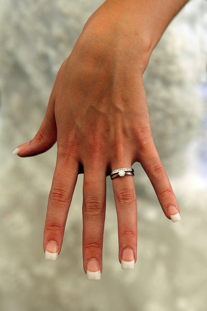 person wearing silver-colored bridal rings