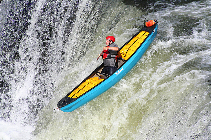 person on teal kayak during daytime