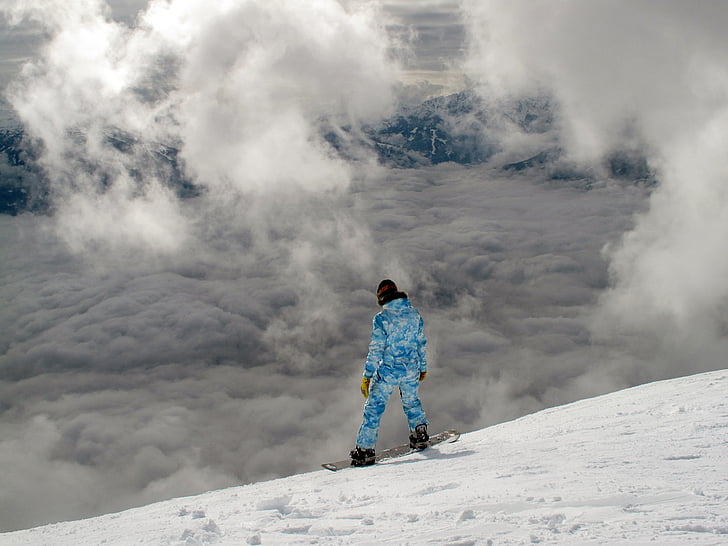 man in blue jacket and trouser on snowboard