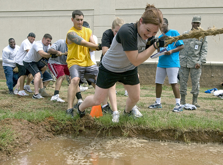woman wearing gray and black crew-neck shirt while playing tug of war