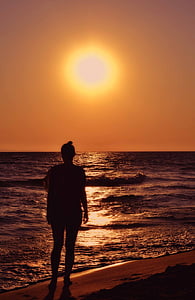 silhouette of woman standing on shore